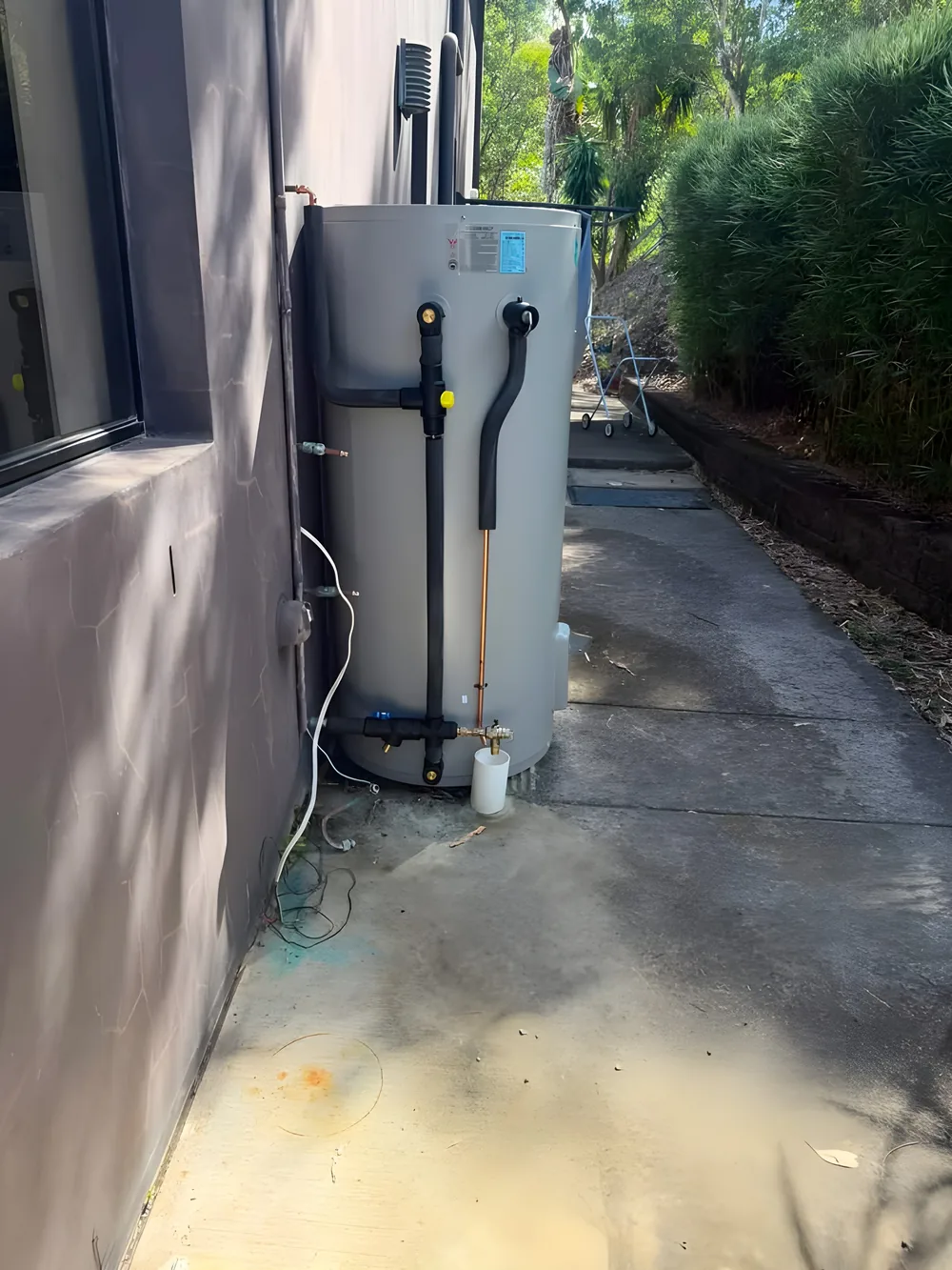 Hot water unit installed down the side of a rendered house