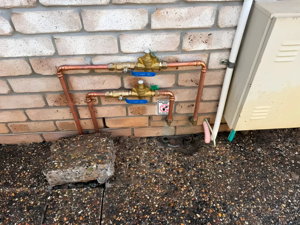 New copper pipework and brass valves fitted to a brick wall