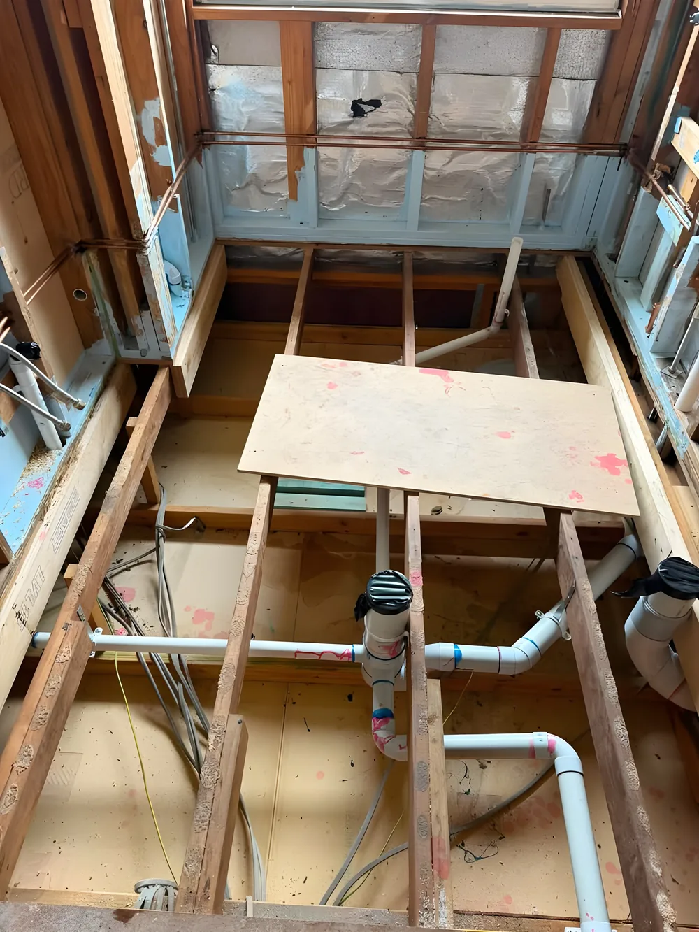 Drainage rough-in through floor joists on a renovation
