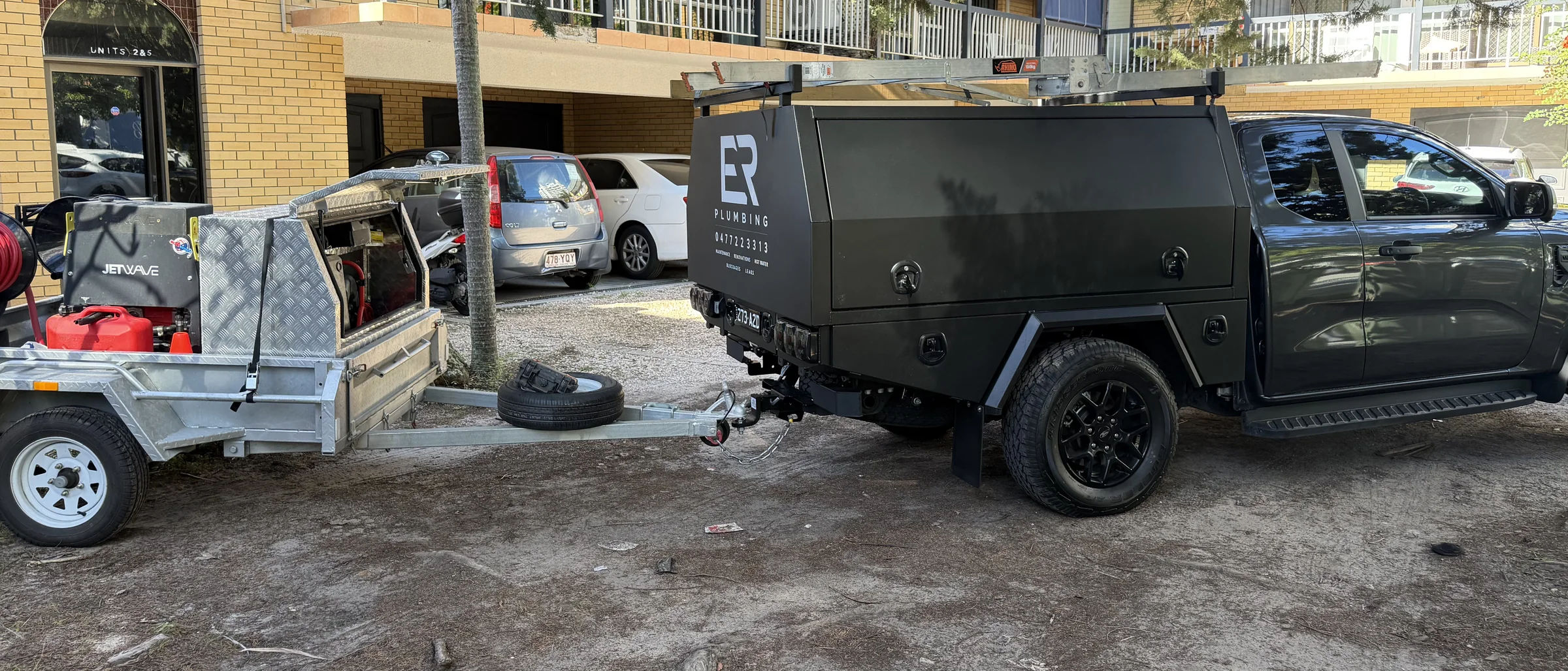 ER Plumbing's black ute and jetting trailer parked on the Gold Coast